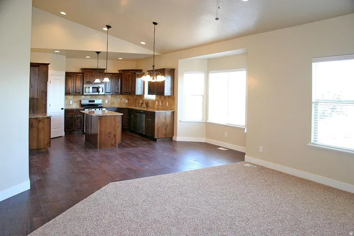 Kitchen with wood-finish flooring, dark wood cabinetry, a center island, and stainless steel appliances