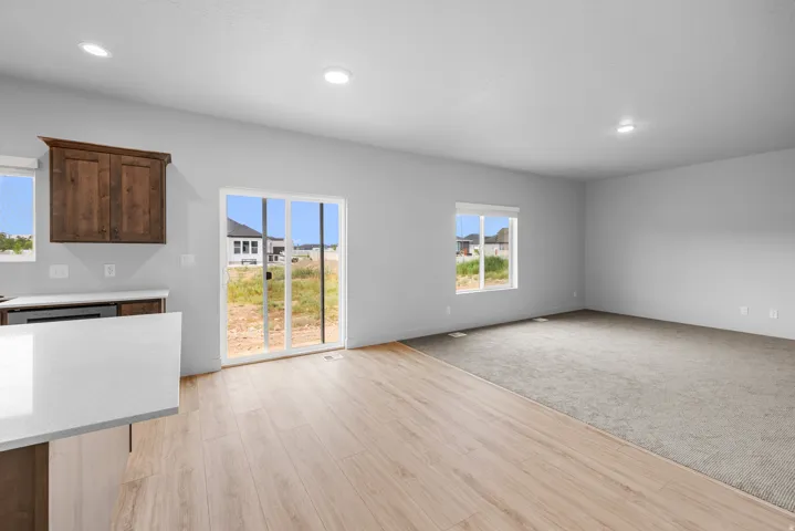 Open-concept living area featuring wood-finish flooring, recessed lighting, and a sliding glass door