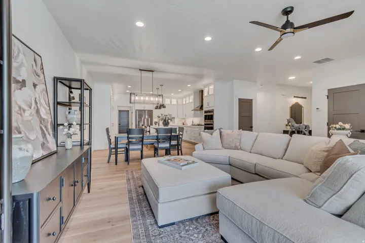 Open-concept living space with light wood-finish flooring, recessed lighting, and a contemporary ceiling fan