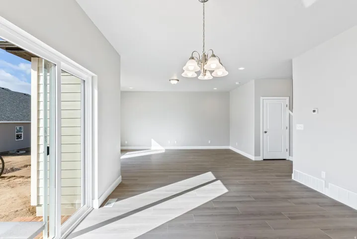 Spacious open-concept room with wood-finish flooring