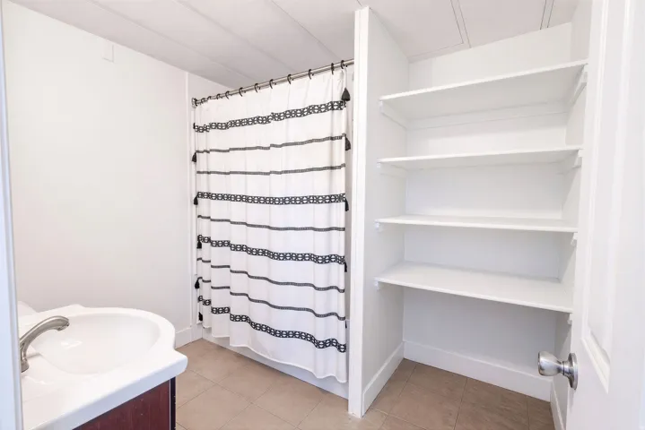 White vanity with integrated sink, brushed nickel faucet, and wood-finish cabinetry
