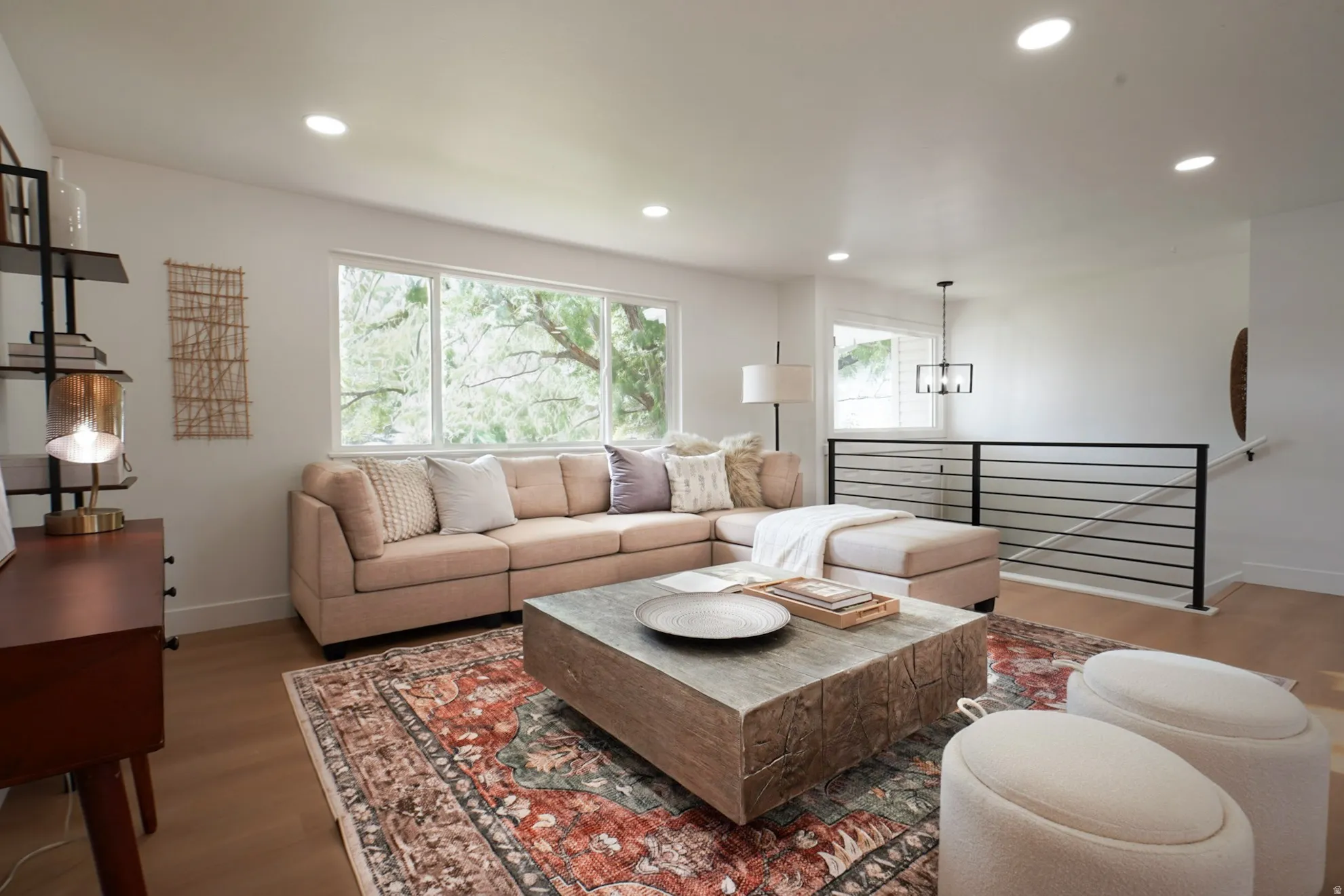 Bright living area featuring wood-finish flooring, recessed lighting, and large windows