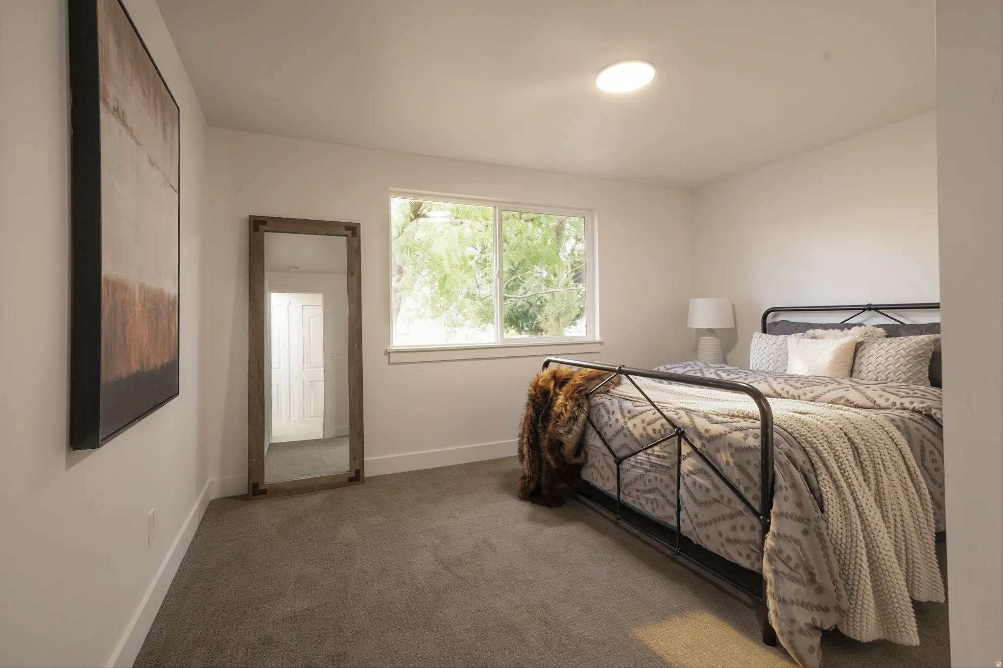 Carpeted room with a recessed ceiling light, white walls, and a window with white trim