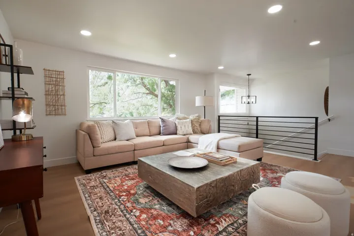 Bright living area featuring wood-finish flooring, recessed lighting, and large windows