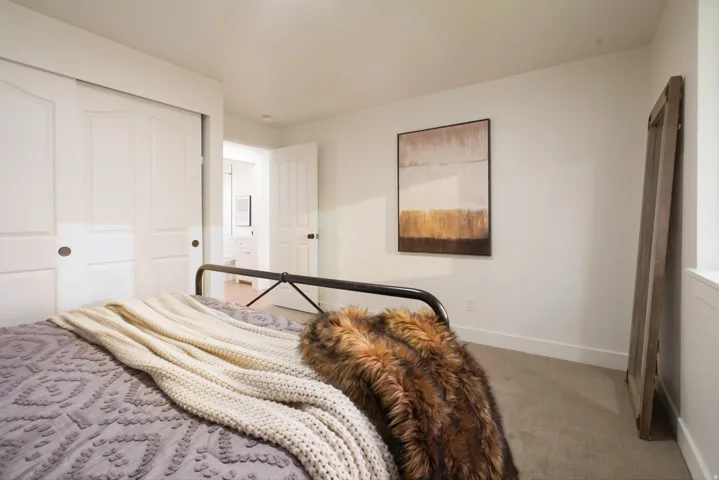 Neutral carpeting, white walls, white trim, and white paneled doors