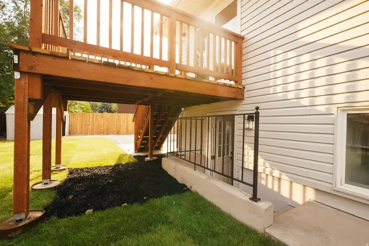 Wood-finish elevated deck with balustrade, supported by sturdy posts