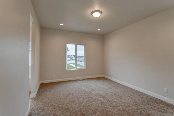 Neutral-toned walls, recessed lighting, and a single window with white trim