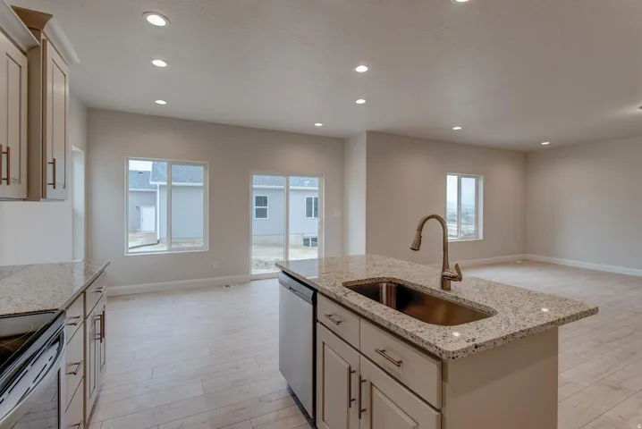 Kitchen island with an undermount sink, granite-style countertop, and a gooseneck faucet