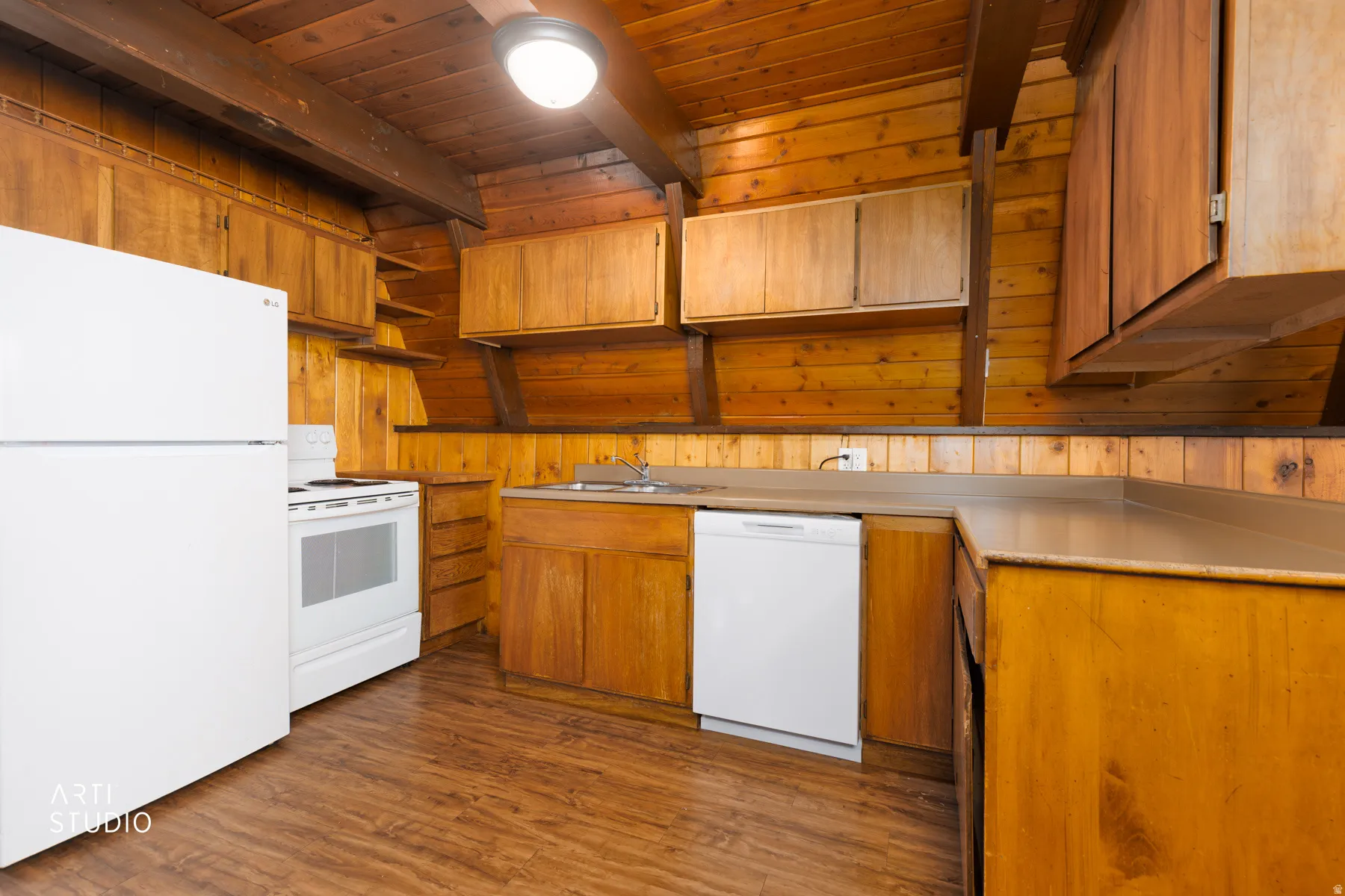 Wood-finish flooring, wood cabinetry, and a ceiling fan with integrated lighting