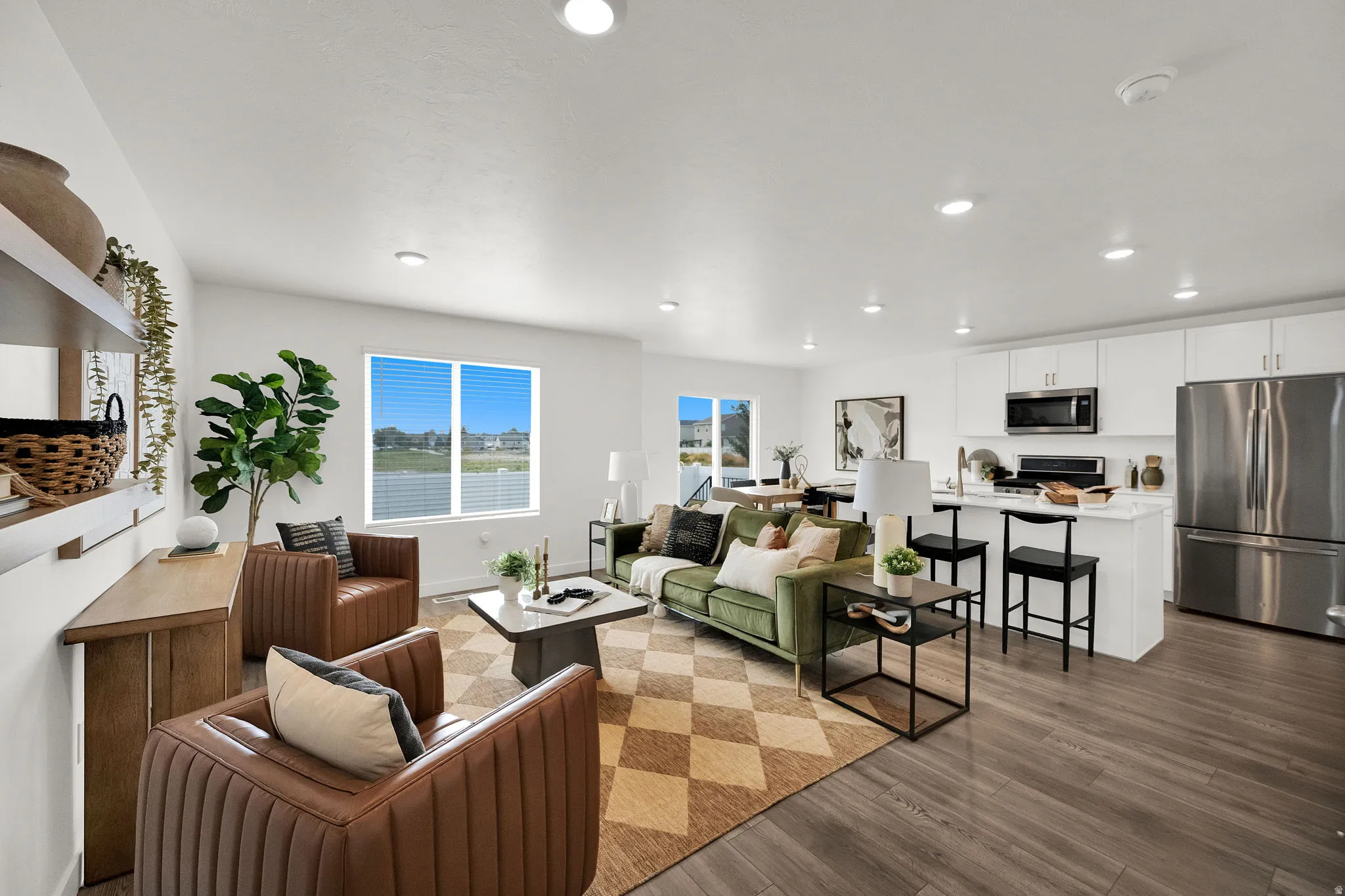 Open concept living area featuring wood-finish flooring, recessed lighting, and a kitchen island with seating