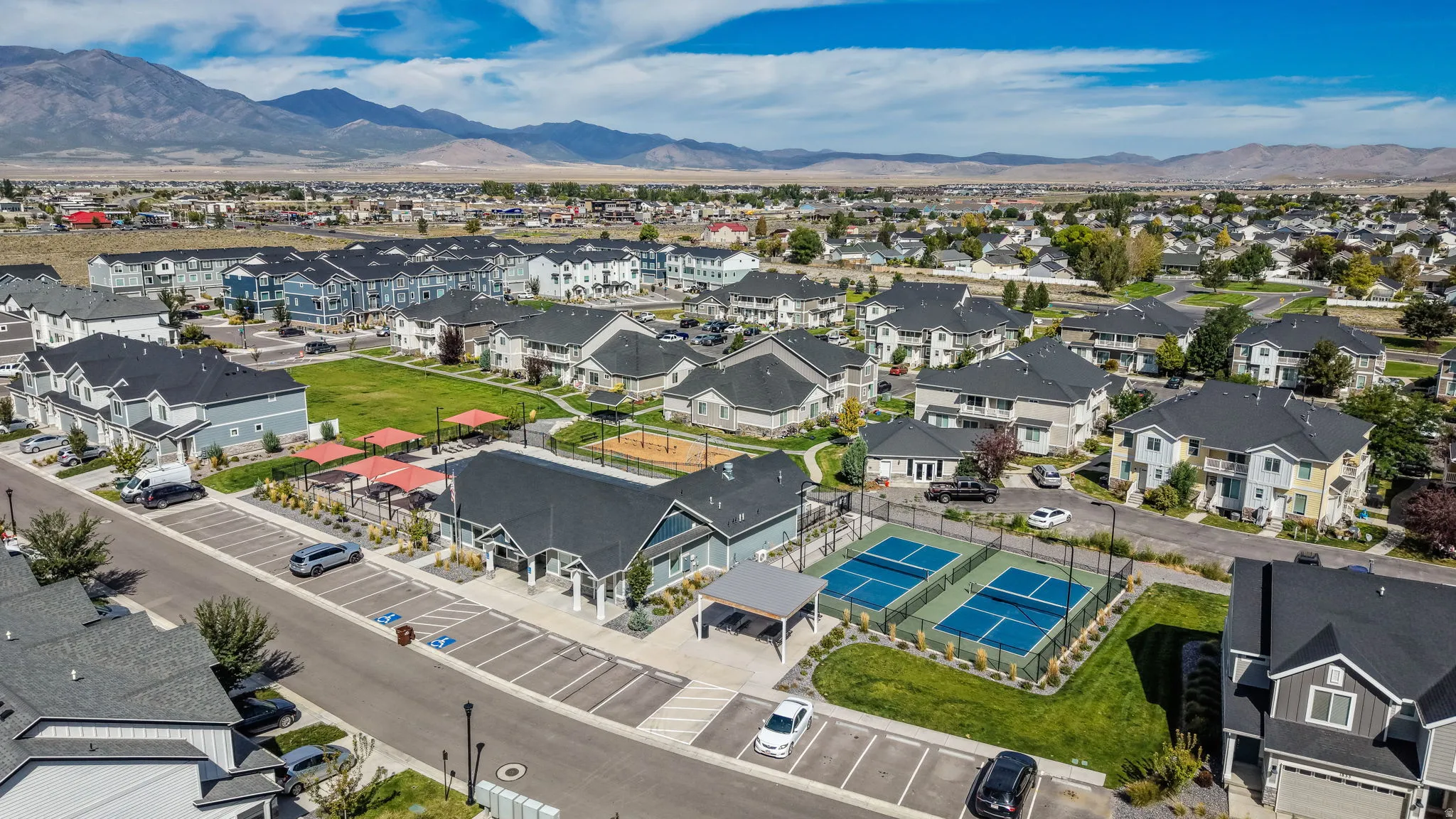 Community with multiple residential buildings, two outdoor pickleball courts, and a central green space
