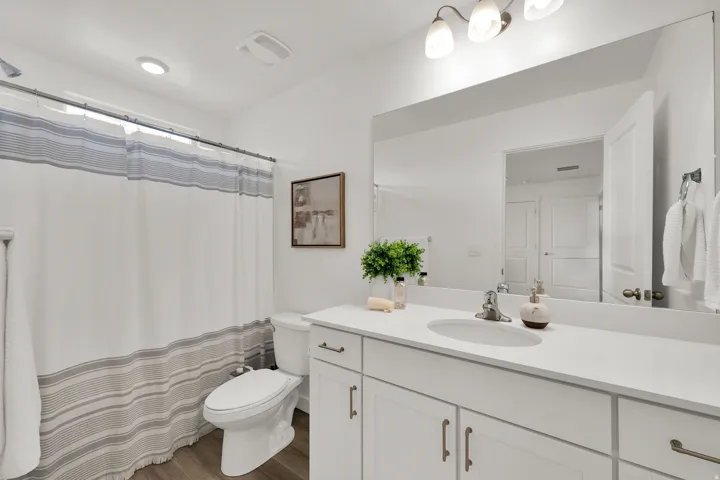 Single vanity with a light-toned countertop, integrated sink, and brushed nickel hardware