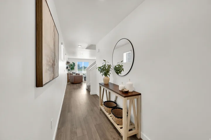 Wood-finish flooring throughout, white painted walls, and recessed lighting