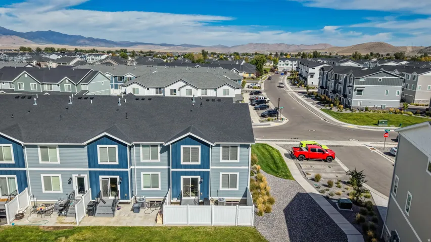 Townhome exterior featuring varied siding colors, individual private patios, and a gravel landscape border