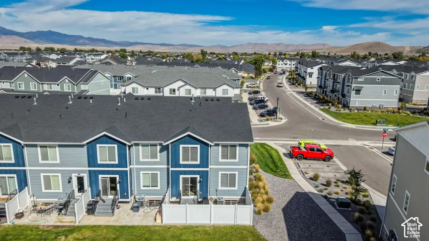 Townhome exterior featuring varied siding colors, individual private patios, and a gravel landscape border