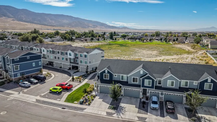 Townhome community with mountain scenery, attached garages, and paved driveways