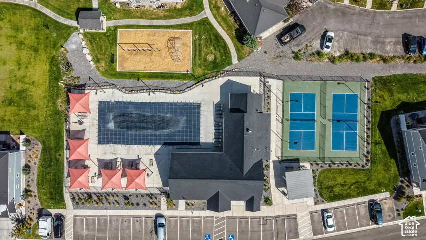 Community amenities featuring a swimming pool, shaded lounge areas, two pickleball courts, a playground, and ample parking