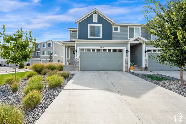Contemporary exterior with mixed siding, stone accents, and an attached two-car garage