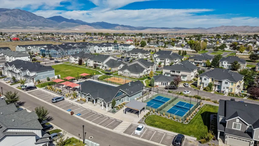 Community with multiple residential buildings, two outdoor pickleball courts, and a central green space