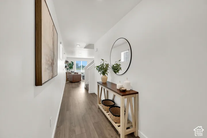 Wood-finish flooring throughout, white painted walls, and recessed lighting