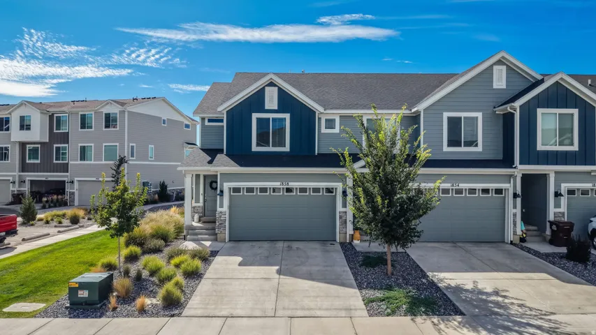 Contemporary multi-story exterior with a two-car garage, concrete driveway, and stone accents