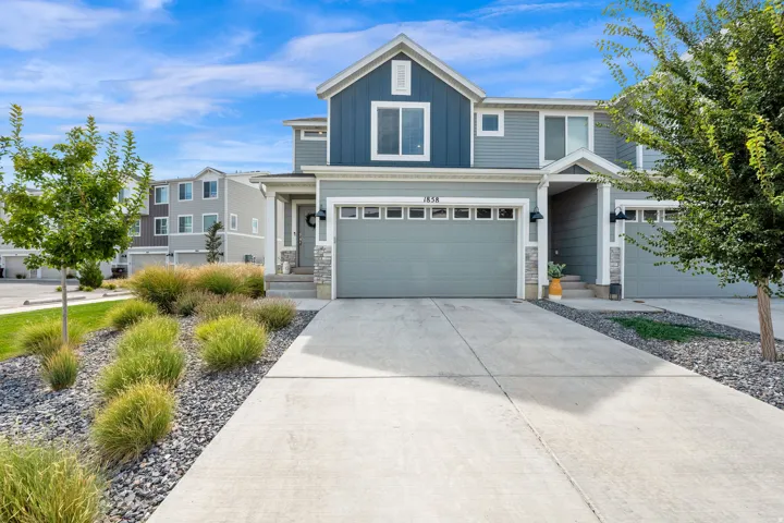 Contemporary exterior with mixed siding, stone accents, and an attached two-car garage