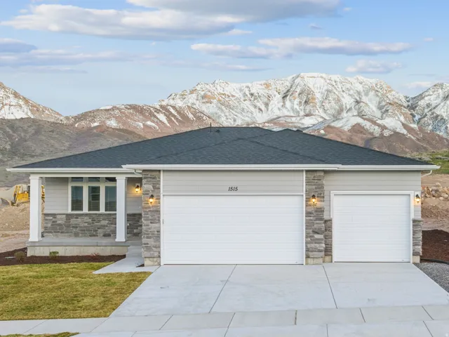 Single-story residence featuring a two-car garage, stone and siding exterior, and concrete driveway