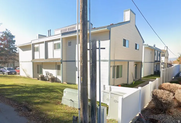 Multi-story residential buildings with light-colored siding, a pitched roofline, and multiple windows
