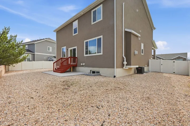 Stucco exterior with multiple windows and a sliding glass door