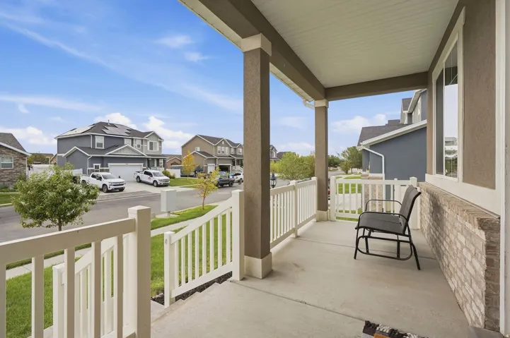 Covered porch with concrete flooring and white railing