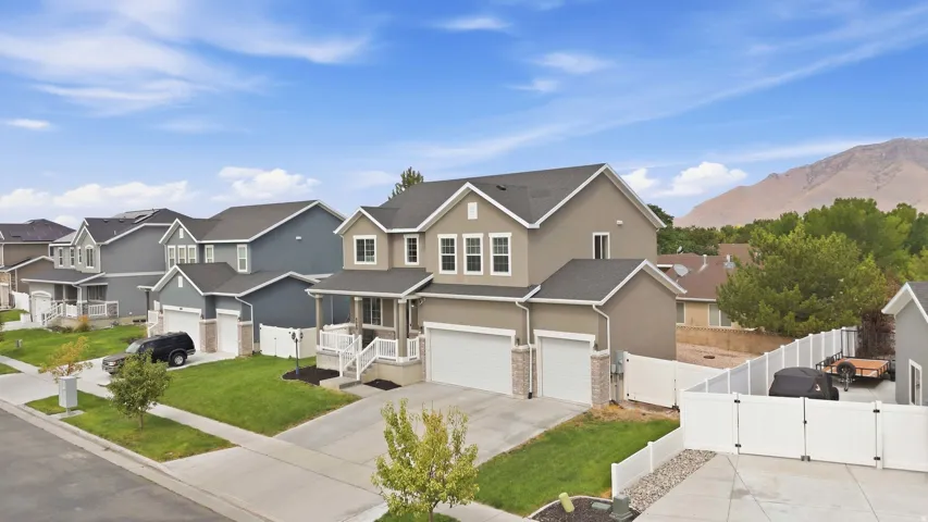 Two-story residence with a dual garage, covered entry porch, and a rear vinyl privacy fence