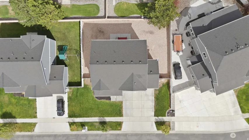 Well-maintained property with a pitched roof, concrete driveway, and established green lawn
