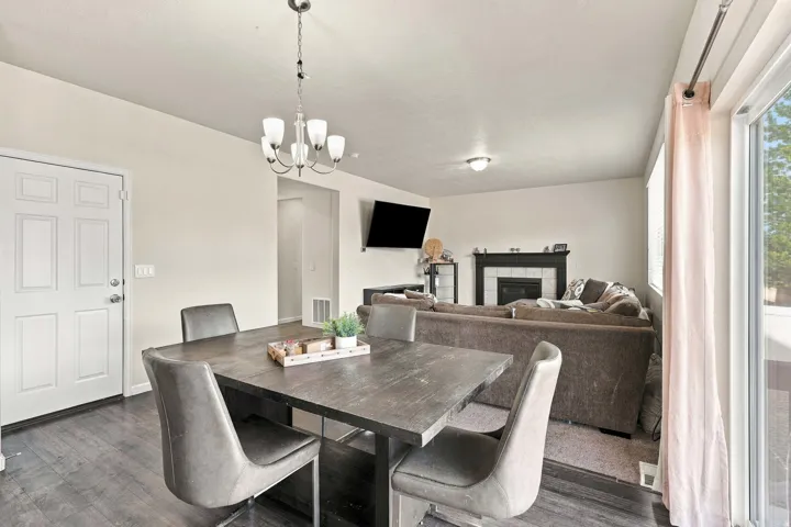 Wood-finish flooring, white paneled door, and a multi-light chandelier
