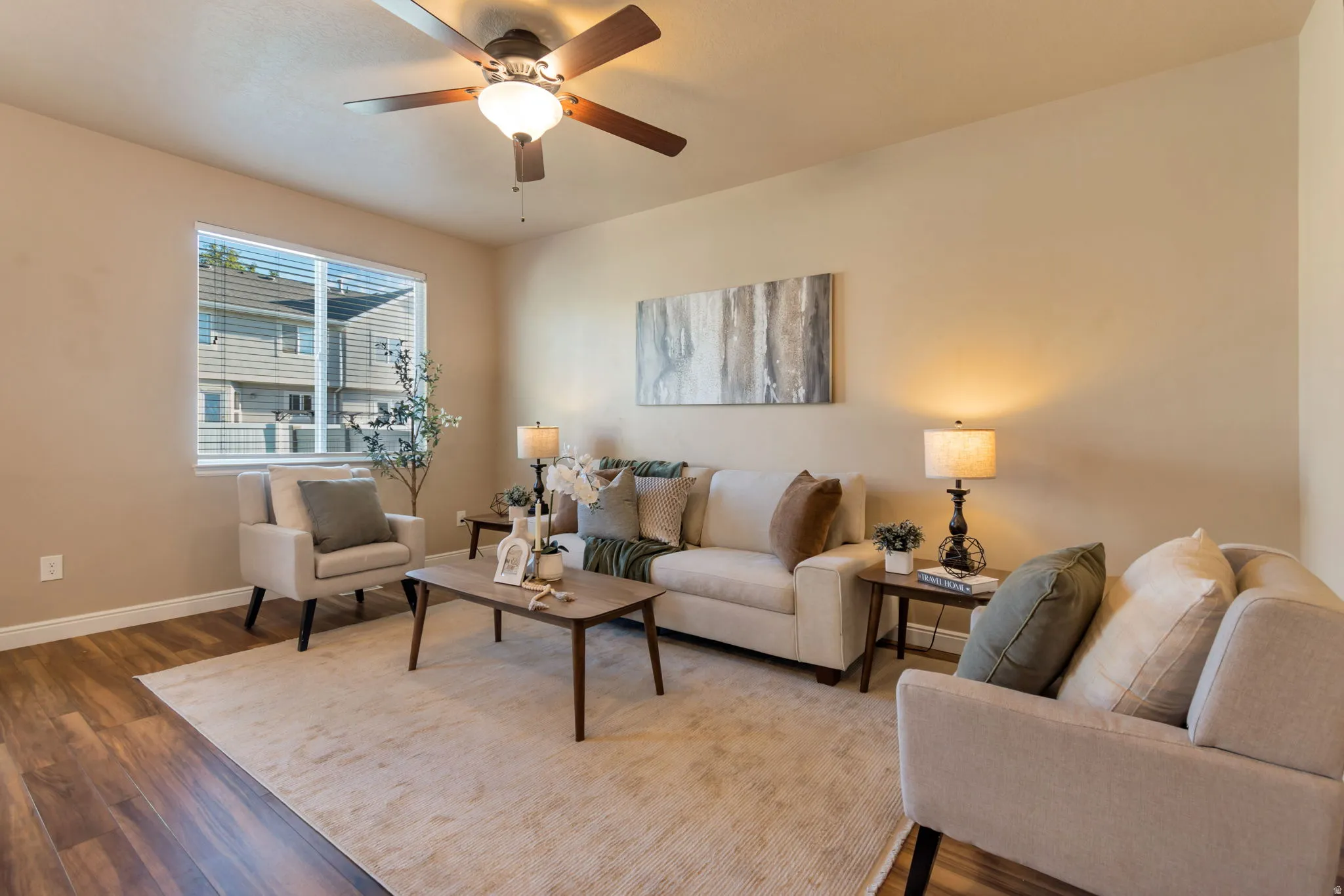 Neutral wall tones, wood-finish flooring, and a ceiling fan with integrated lighting