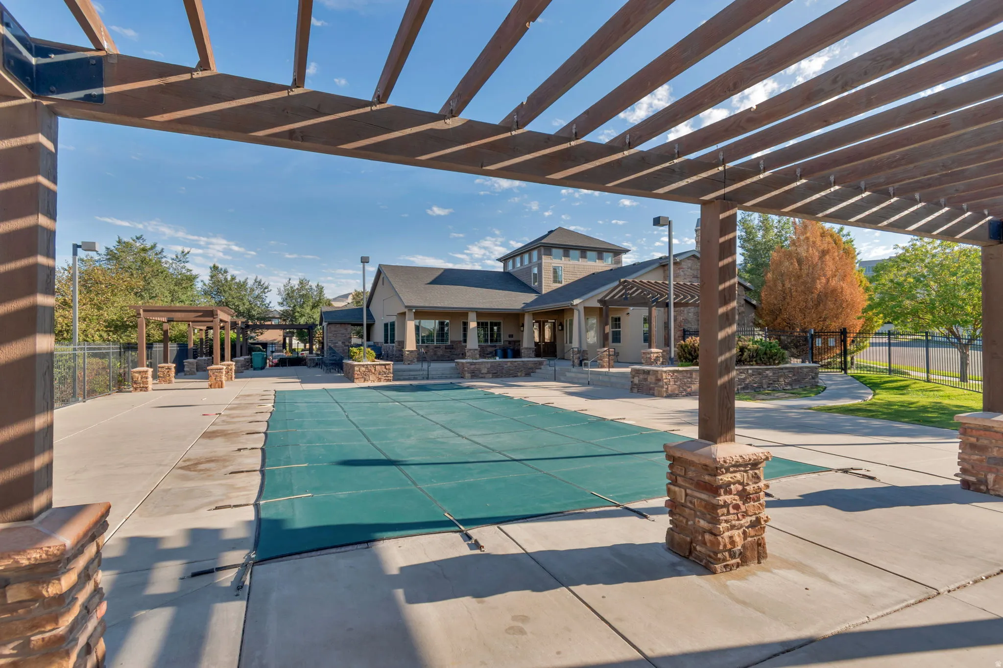 Wood pergola structure over paved pool deck