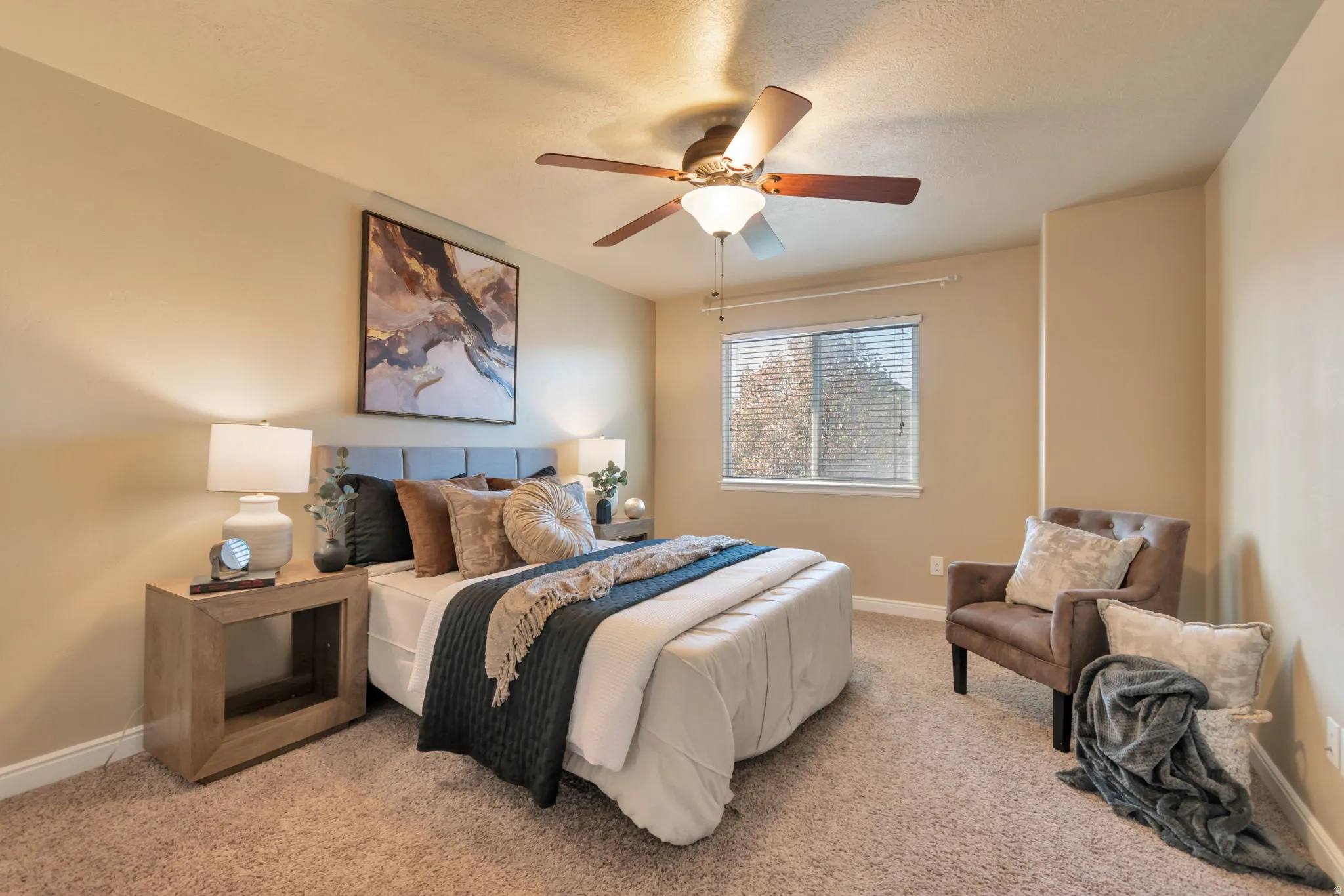 Primary Bedroom. Carpeted flooring, window with blinds, ceiling fan, and recessed wall feature