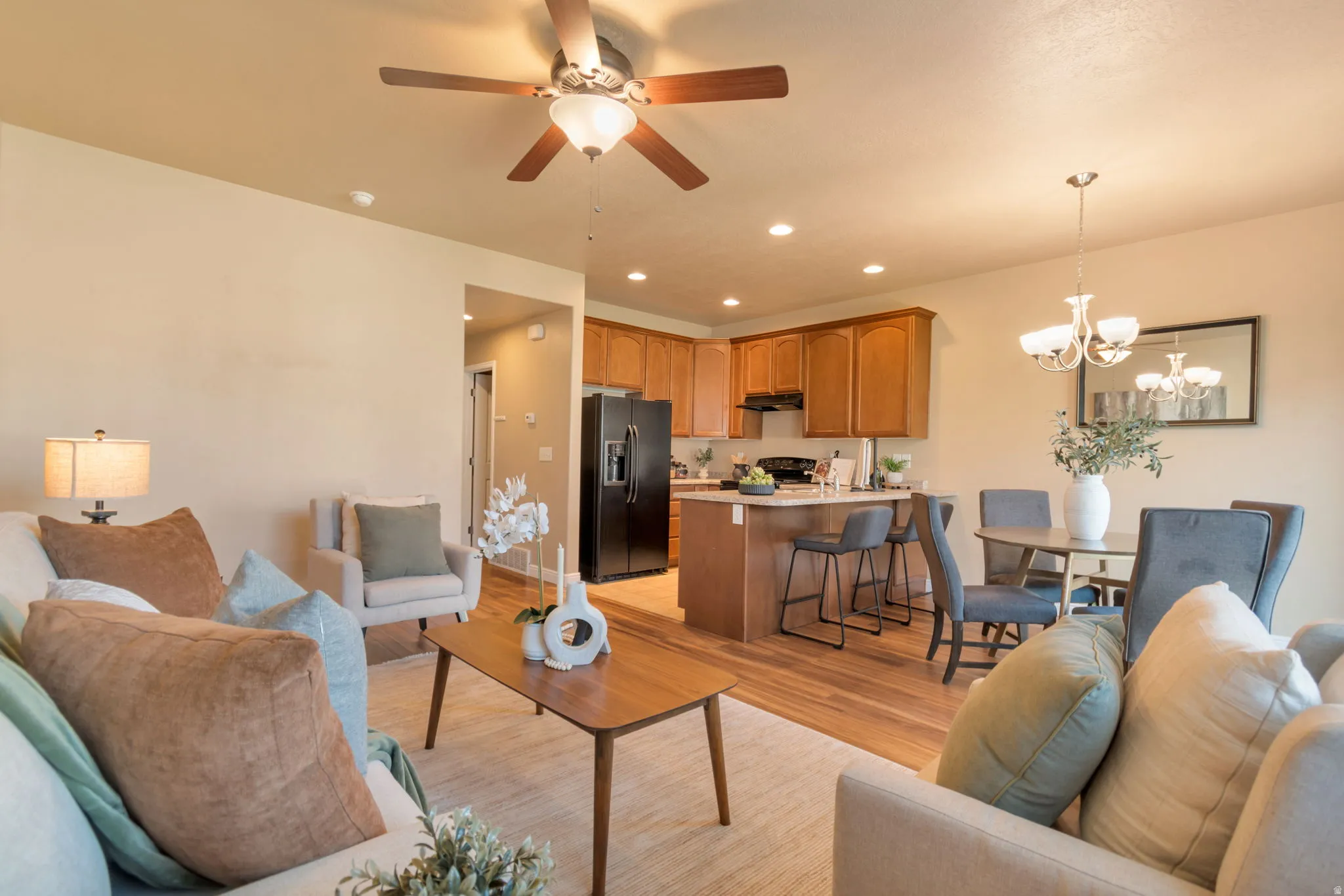 Open-concept living area featuring wood-finish flooring, recessed lighting, and a ceiling fan