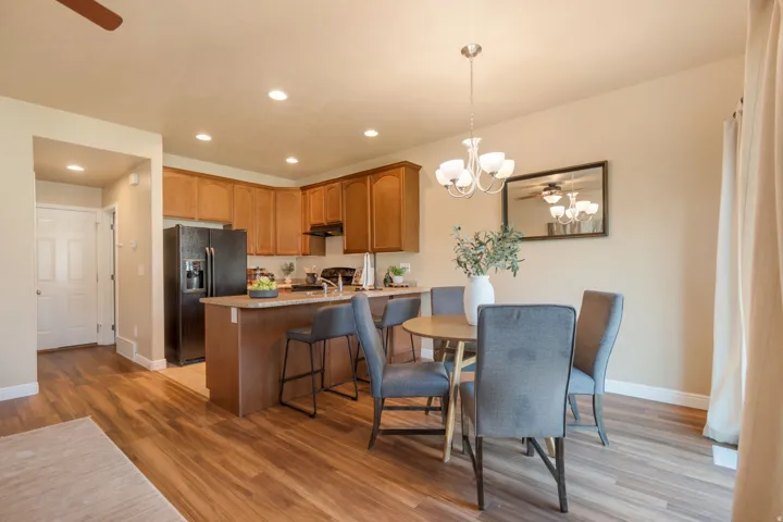 Wood-finish flooring throughout, recessed lighting, and a kitchen island with seating