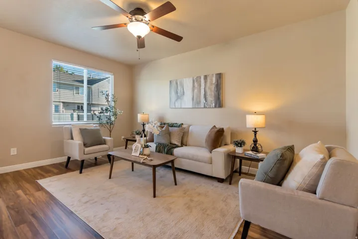 Neutral wall tones, wood-finish flooring, and a ceiling fan with integrated lighting
