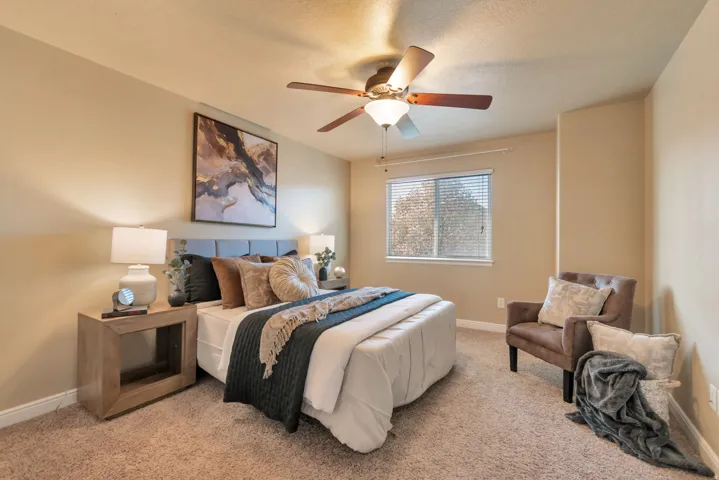 Primary Bedroom. Carpeted flooring, window with blinds, ceiling fan, and recessed wall feature