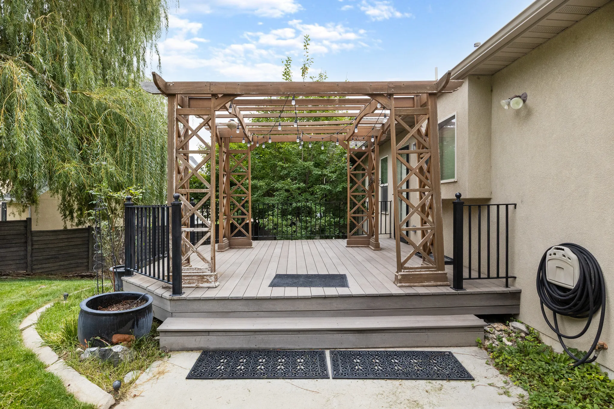 Wood-finish deck with a decorative pergola and string lighting