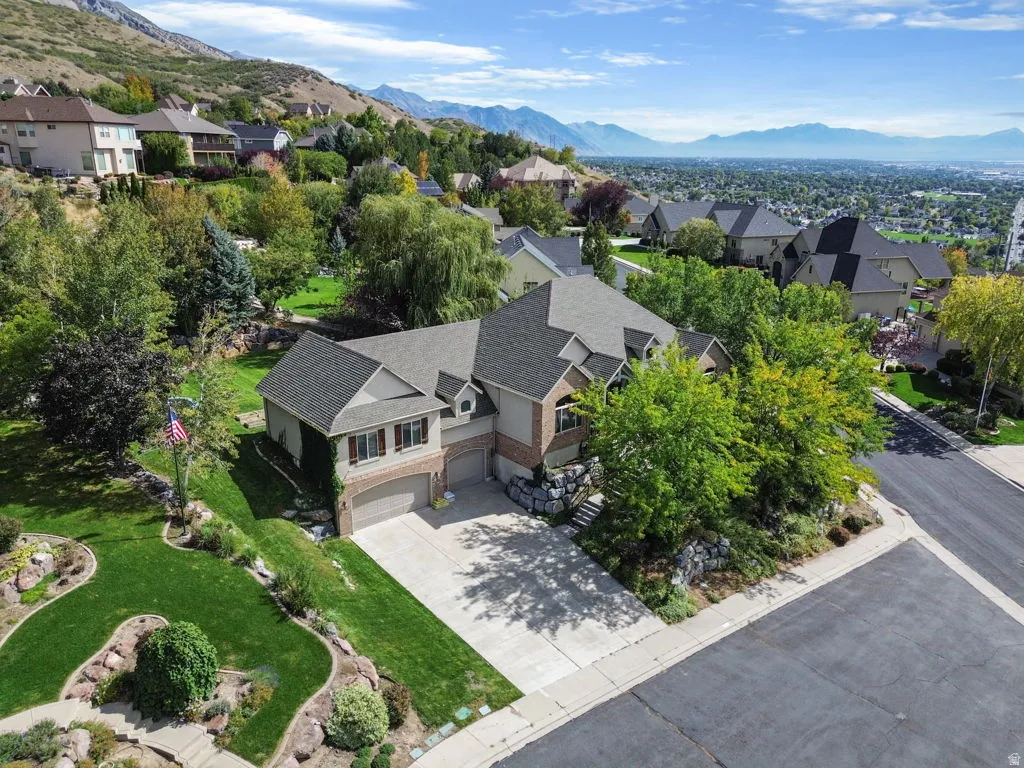 Two-story residence with a multi-gabled roofline, brick and siding exterior, attached two-car garage, and landscaped grounds