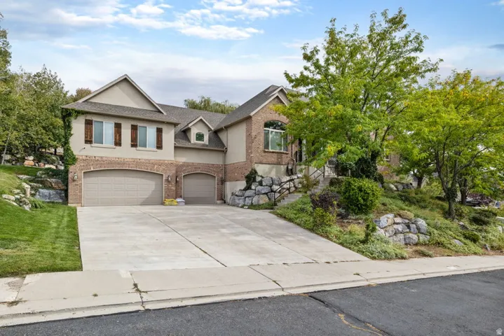 Two-story exterior with brick and stucco finish, dual garage doors, and a concrete driveway