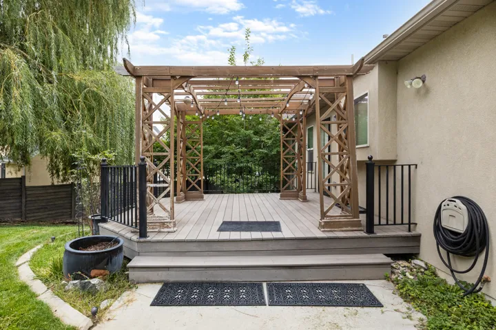 Wood-finish deck with a decorative pergola and string lighting