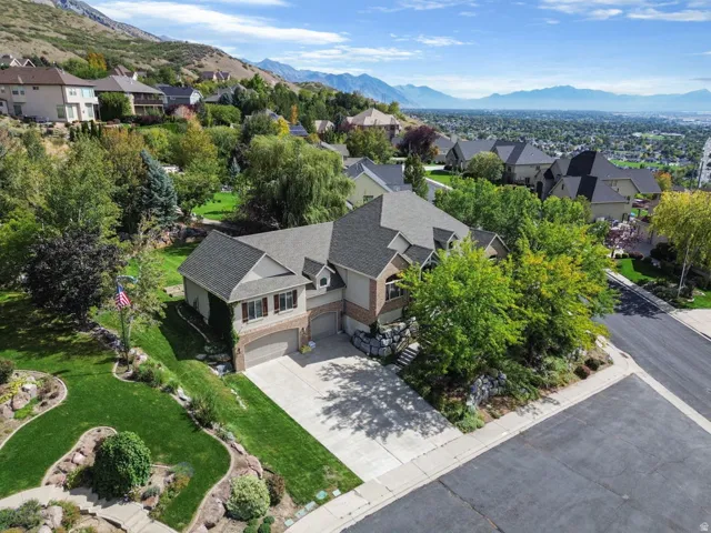 Two-story residence with a multi-gabled roofline, brick and siding exterior, attached two-car garage, and landscaped grounds