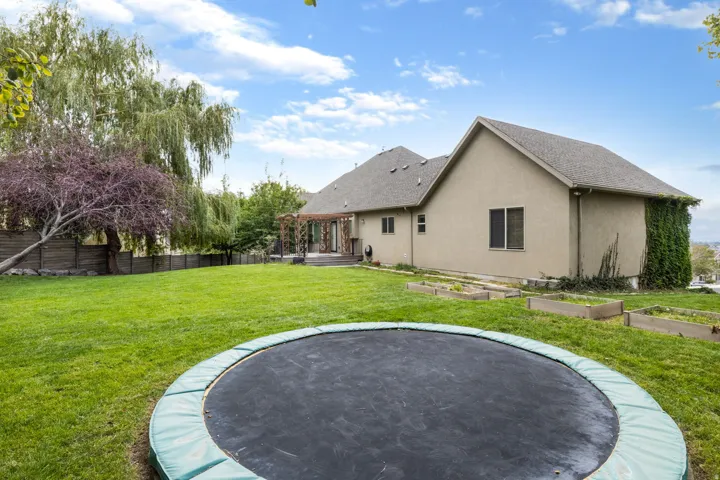 Expansive lawn with mature trees and a privacy fence