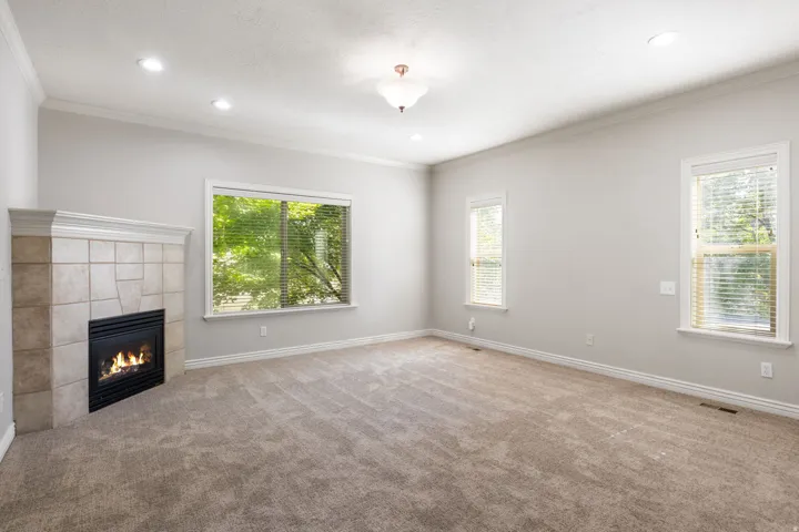 Spacious room with a tiled fireplace, recessed lighting, and multiple windows
