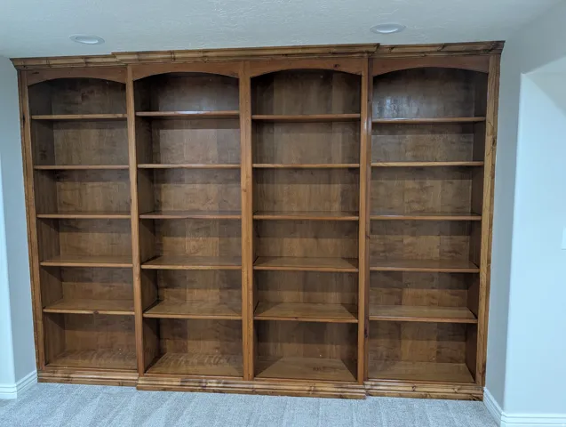 Built-in wood shelving with arched tops and crown molding details
