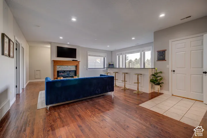 Hardwood flooring, recessed lighting, and a built-in fireplace with a wood mantel