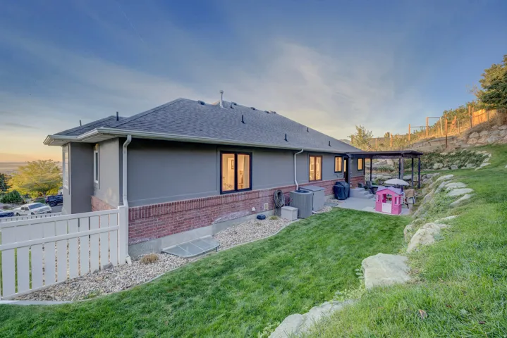 Expansive backyard featuring a manicured lawn, a concrete patio, and a covered pergola